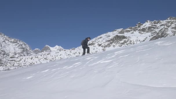 イタリアのアルプスの尾根を雪の中を歩くのに苦労したハイカー — ストック動画