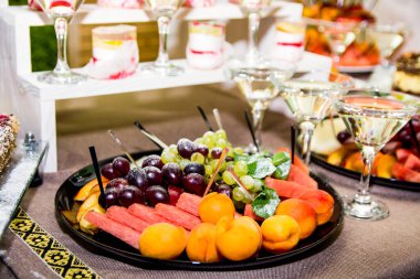 Düğün resepsiyonunda lezzetli tatlılar ve aperatiflerle birlikte çikolata. Çiçek kompozisyonları ve mumlarla süslenmiş. Tatlı yemek, tatlı, açık büfe, yemek masası, restoran..