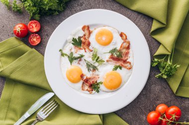 Beyaz bir tabak üzerinde pastırma ile tost yumurta.