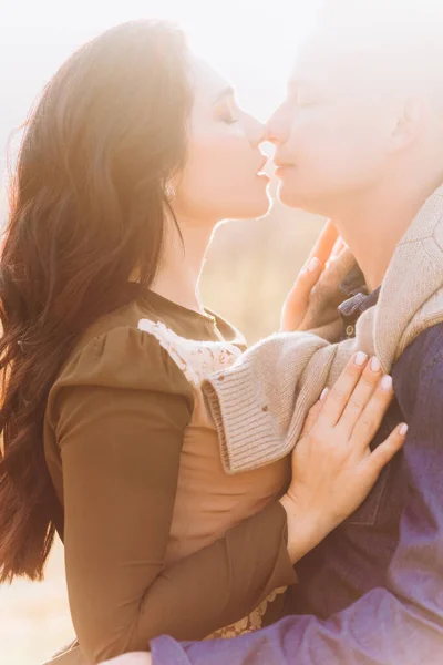 Casal amoroso ao pôr-do-sol. Namorado elegante e namorada beijar uns aos outros . — Fotografia de Stock