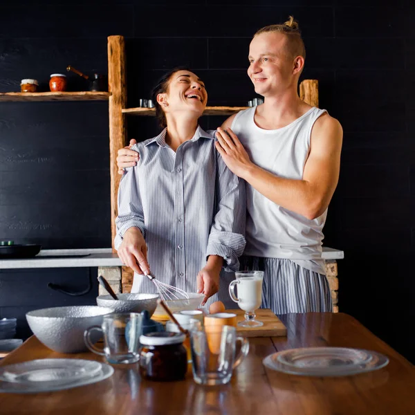 Unga par i kärlek kockar tillsammans i ett kök. En kille och en tjej tillbringar tid tillsammans i en ny lägenhet. Hushållens uppvärmning. — Stockfoto