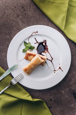 Kahvaltıda. Çikolatalı krep, süzme peynir, tabakta konsantre süt.. 