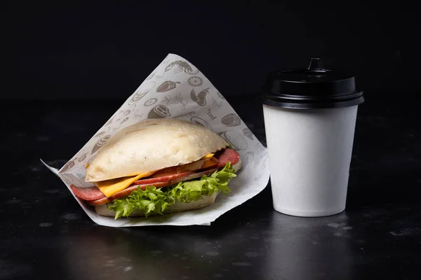 Siyah arka planda sandviç ve kahve. Fast food. Burgeer.