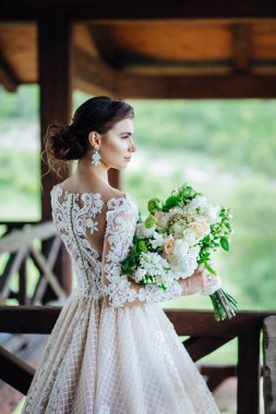 Gelin, görkemli, beyaz, gelinlik ve düğün çiçekleri içinde..