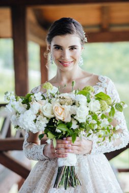 Gelin, görkemli, beyaz, gelinlik ve düğün çiçekleri içinde..