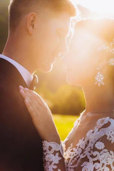 Beijo amor noiva e noivo. Feliz juntos contra o pano de fundo da grama verde e um lago ao pôr do sol. — Fotografia de Stock