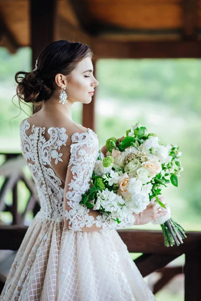The bride in a magnificent, white, wedding dress with a wedding flowers. — Stock Photo, Image