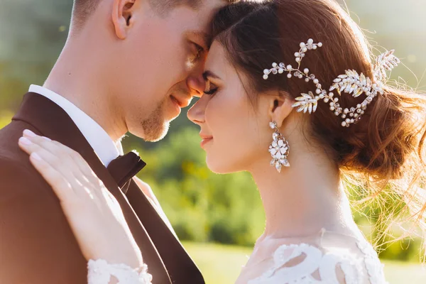 Beijo amor noiva e noivo. Feliz juntos contra o pano de fundo da grama verde e um lago ao pôr do sol. — Fotografia de Stock