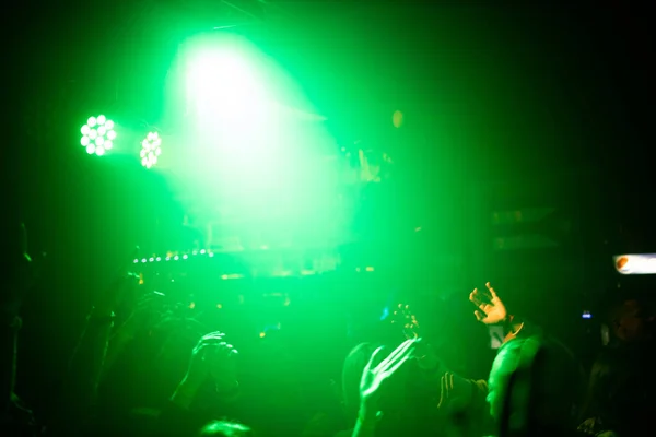 People at a concert in the light of spotlights. rock concert. — Stock Photo, Image