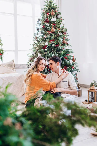 Milující pár dává jeden druhému dárky k Vánocům v blízkosti vánočního stromečku. — Stock fotografie