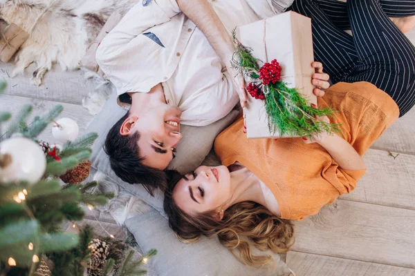 Birbirini seven çiftler Noel ağacının yanında birbirlerine Noel hediyesi verirler.. — Stok fotoğraf