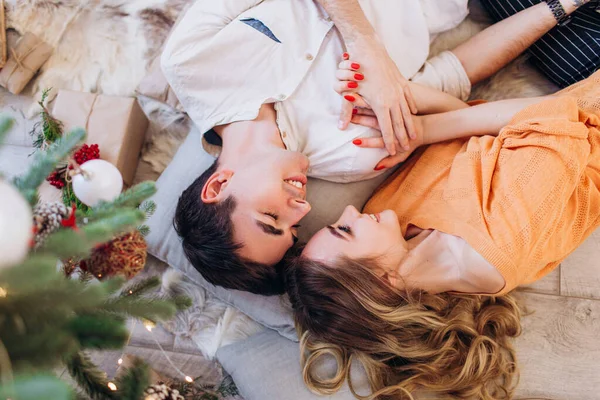 Casal amoroso dá um ao outro presentes para o Natal perto da árvore de Natal . — Fotografia de Stock