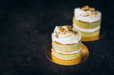 Beyaz kremalı ve siyah arkaplanlı kekler. Pişirme ve tatlılar.