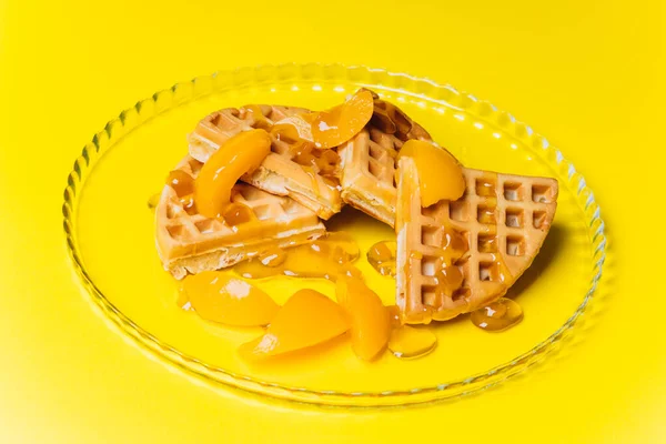 Waffeln mit Pfirsichen zum Frühstück auf gelbem Hintergrund. — Stockfoto