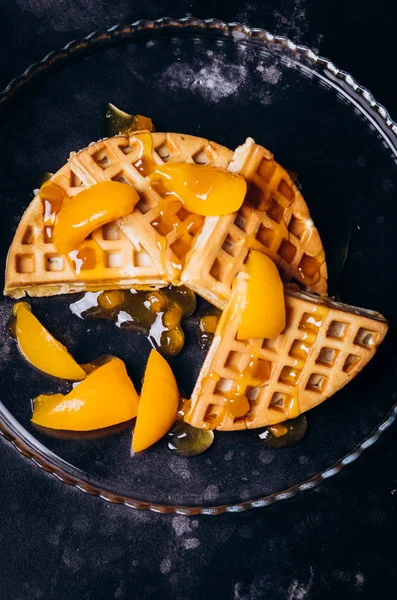 Waffles with peaches for breakfast on a black background. — ストック写真