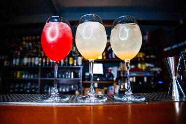 Parlak alkollü kokteyller. Sarı ve kırmızı meyve püresi. Alkol çeşitleri. Çubuk.