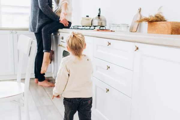 Család a világos konyhában. A gyermek szerető szülőkhöz kerül. Első lépések. — Stock Fotó
