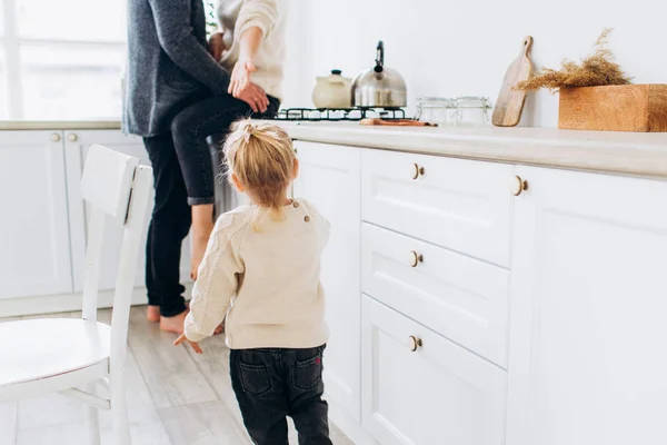 Family on the bright kitchen. The child goes to loving parents. First steps. — Stock Photo, Image