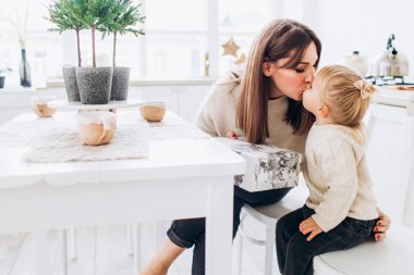 Anne ve kızı parlak bir mutfakta. Homellik. Neşeli bebek ve annesi. 