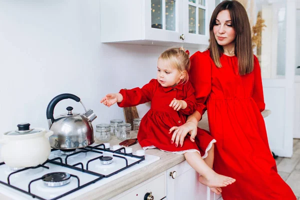 Mor och dotter i ett ljust kök. Hemtrevnad. Glädjande bebis och hans mamma. — Stockfoto