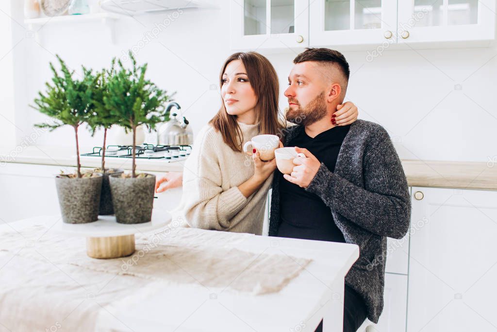 Loving couple drinks tea in the kitchen. Relations. Young family.