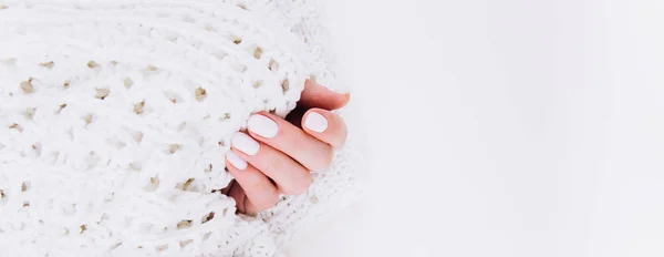 Stylish trendy white manicure. Tender female hands.