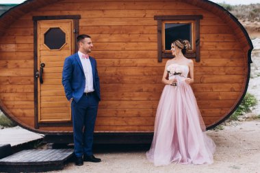 Deniz kıyısında, ahşap evin yanında birbirini seven bir çift. Düğün için. Yeni evliler.