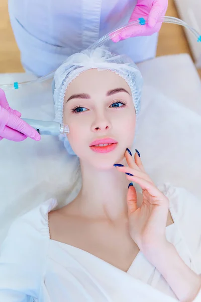 Hardware-Hautpflege. Ein junges Mädchen pflegt ihr Gesicht. Schönheitsbehandlung. Verfahren. Werbung. — Stockfoto