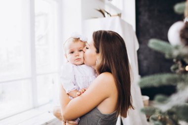 Anne gülümser ve kızını öper. Mutlu bir aile. Bir annenin portresi..