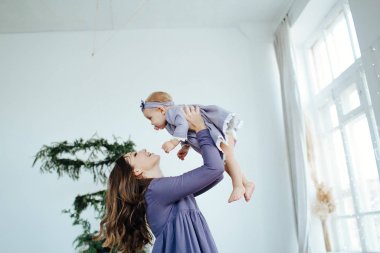 Anne gülümser ve kızını öper. Mutlu bir aile. Bir annenin portresi..