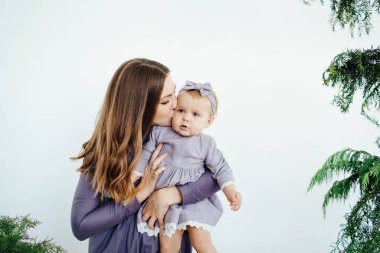 Anne gülümser ve kızını öper. Mutlu bir aile. Bir annenin portresi..