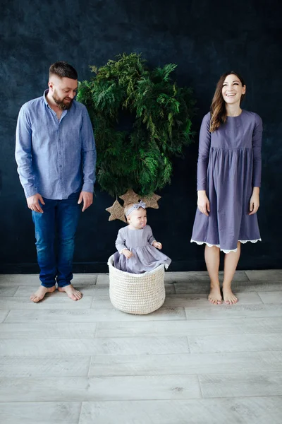 Rodina tří dětí na pozadí novoroční zdi v modrých šatech. — Stock fotografie