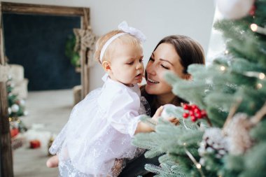 Anne gülümser ve kızını öper. Mutlu bir aile. Bir annenin portresi..