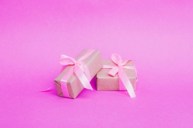 Parşömene sarılı hediyeler, eko kağıtlar, pembe arka planda kraft kağıtları..