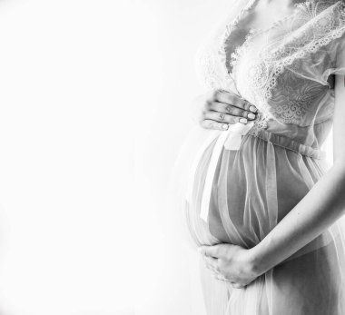 Siyah beyaz arka planda hamile karnı. Hassas hamilelik.