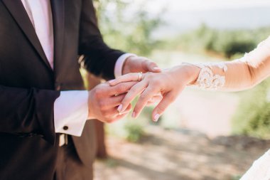 Gelin ve damadın elinde alyanslar.