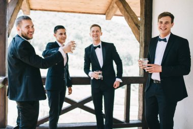 Damat ve arkadaşları düğünü kutluyorlar. Takım elbiseli adamlar. Murzhsky duyguları ve dostluğu.