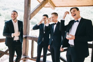 Damat ve arkadaşları düğünü kutluyorlar. Takım elbiseli adamlar. Murzhsky duyguları ve dostluğu.