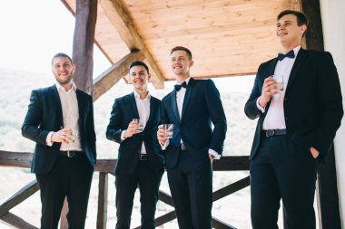 Damat ve arkadaşları düğünü kutluyorlar. Takım elbiseli adamlar. Murzhsky duyguları ve dostluğu.