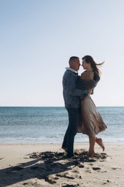 Deniz kıyısında birbirini seven bir çift. Deniz kıyısında dolaşır, yürür.