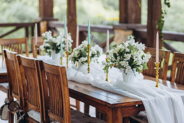 Stół weselny ozdobiony świeżymi kwiatami jest nowożeńcem z widokiem na góry. — Zdjęcie stockowe