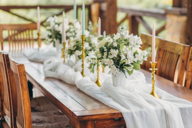 Yeni evliler ve dağ manzaralı konuklar için dekore edilmiş düğün masası. Düğün dekoru ve çiçekçilik..