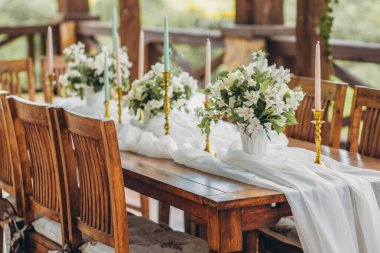 Yeni evliler ve dağ manzaralı konuklar için dekore edilmiş düğün masası. Düğün dekoru ve çiçekçilik..