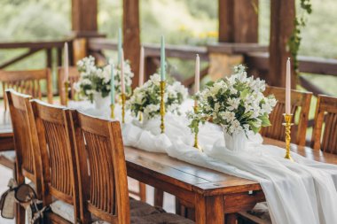 Yeni evliler ve dağ manzaralı konuklar için dekore edilmiş düğün masası. Düğün dekoru ve çiçekçilik..