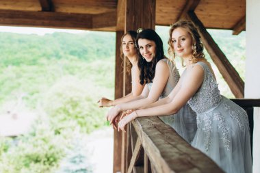 Balkonda uzun elbiseli üç kız. Nedimeler.