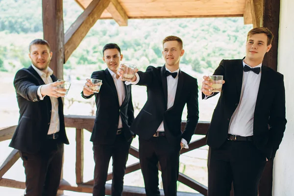 Damat ve arkadaşları düğünü kutluyor ve içki içiyorlar. Takım elbiseli adamlar. Erkeklerin duyguları ve dostluğu.