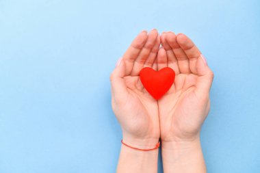 Kalbi mavi bir arka planda ellerinde. Sevgililer Günü ve Kadınlar Günü konsepti. Üst görünüm, metin için yer. bir hayat
