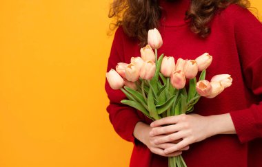 Sarı arka planda izole edilmiş laleli bir kız 8 Mart bayramı konsepti, Sevgililer günü, bahar tatili.