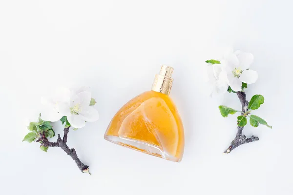 Perfumy Pięknych Żółtych Butelkach Gałęziach Kwitnących Wiosennych Kwiatów Odizolowanych Białym — Zdjęcie stockowe