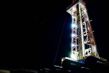 Petrol ve Gaz sondaj kulesi. Petrol ve gaz endüstrisindeki petrol platformunda sondaj sondajı çalışması. Kıyı açıklarındaki Derrick sondaj kulesinin güzel gece manzarası